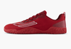 Red athletic shoe with red sole on a white background